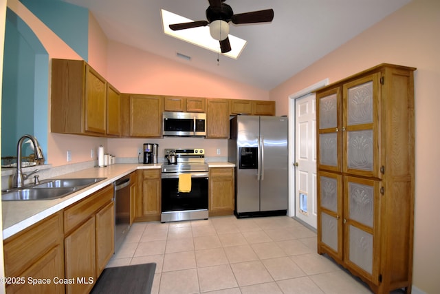 kitchen featuring appliances with stainless steel finishes, lofted ceiling, sink, light tile patterned floors, and ceiling fan