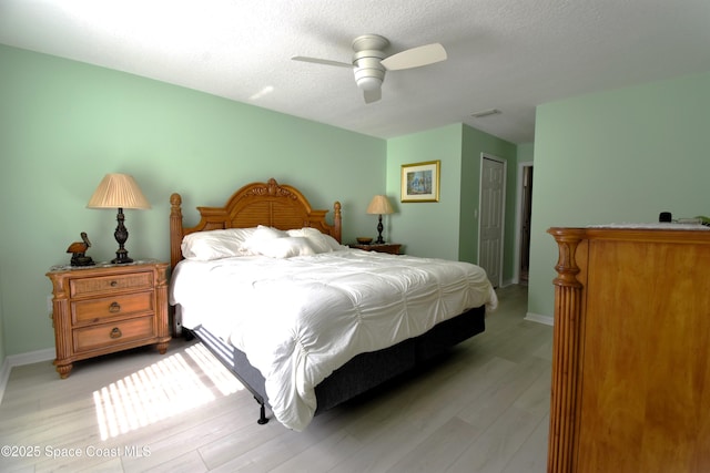 bedroom with a closet, a textured ceiling, ceiling fan, and light hardwood / wood-style flooring