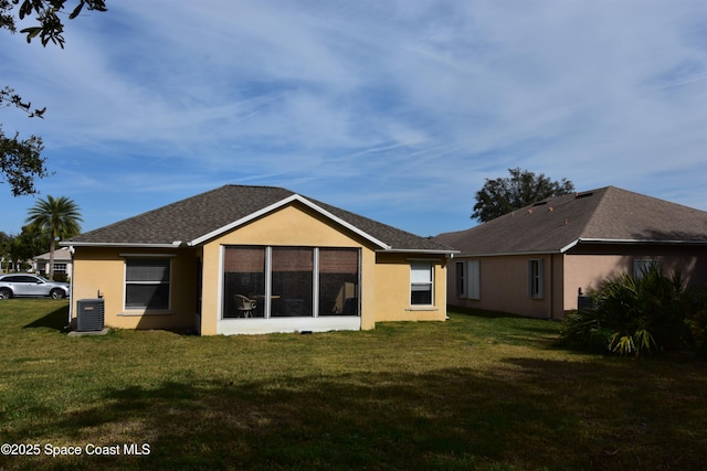 back of house with central AC unit and a lawn