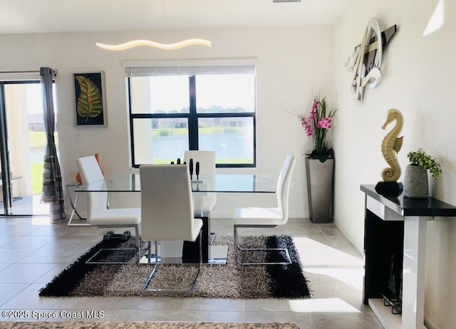 tiled dining area with a water view and plenty of natural light