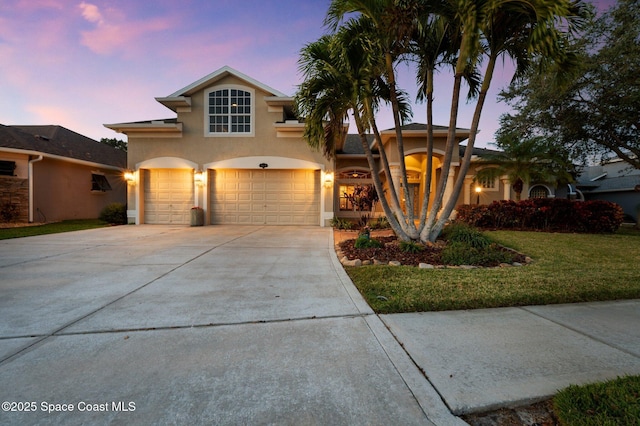 view of front of home with a garage and a lawn