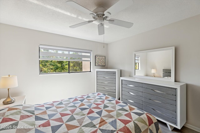 bedroom with ceiling fan and a textured ceiling