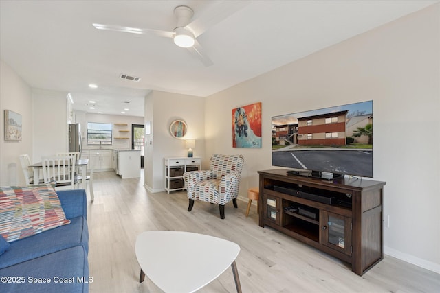 living room with ceiling fan and light hardwood / wood-style floors