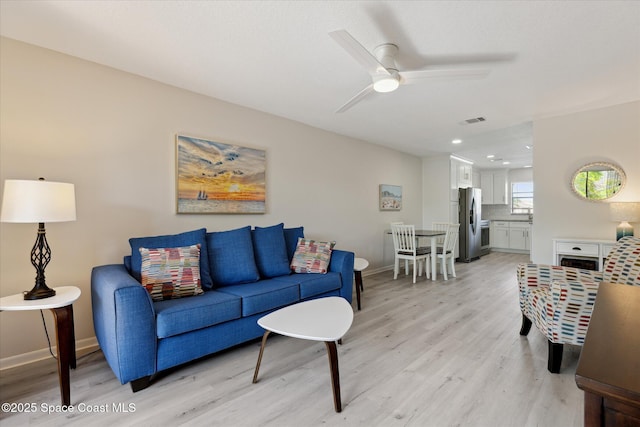 living room with ceiling fan and light hardwood / wood-style floors