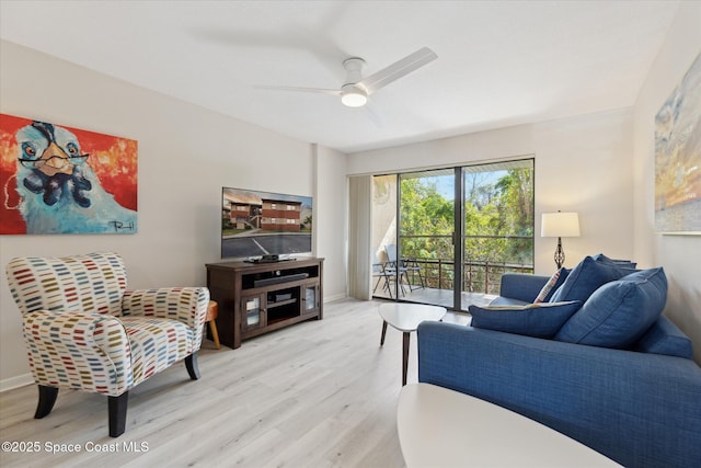 living room featuring ceiling fan and light hardwood / wood-style floors