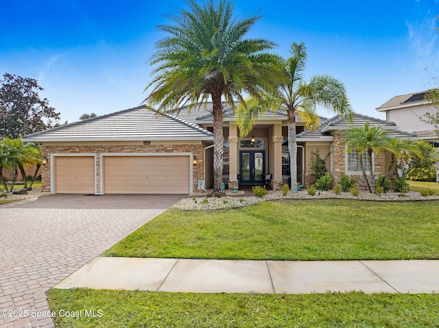 view of front of property with a garage, a front lawn, and french doors