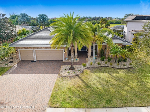 view of front of property featuring a garage, a lanai, and a front lawn