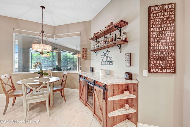 kitchen featuring pendant lighting, a textured ceiling, and light tile patterned floors