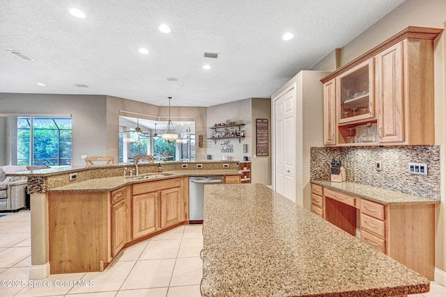 kitchen featuring sink, light stone counters, decorative light fixtures, a center island with sink, and stainless steel dishwasher