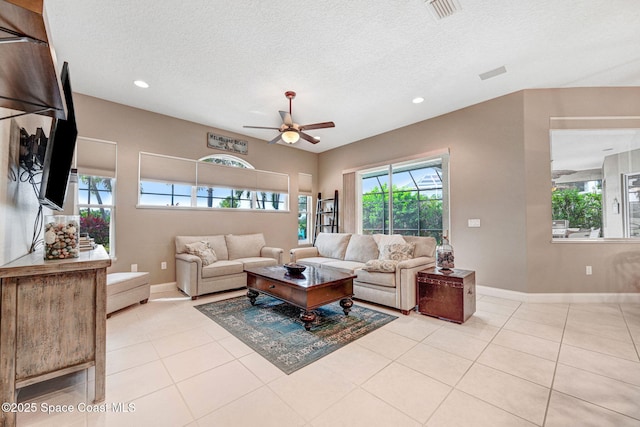 tiled living room with ceiling fan and a textured ceiling