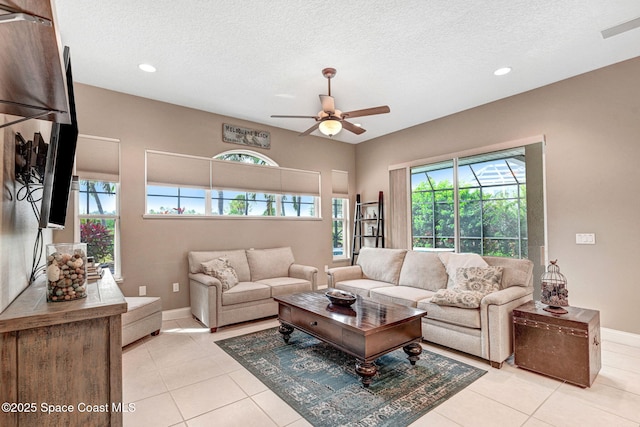 tiled living room featuring ceiling fan and a textured ceiling