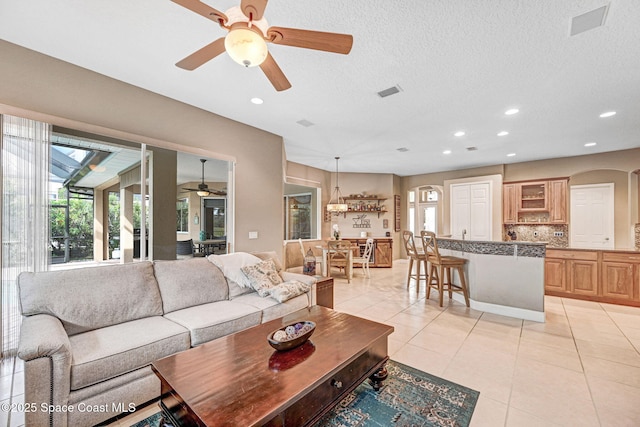 living room featuring a wealth of natural light, a textured ceiling, and light tile patterned floors