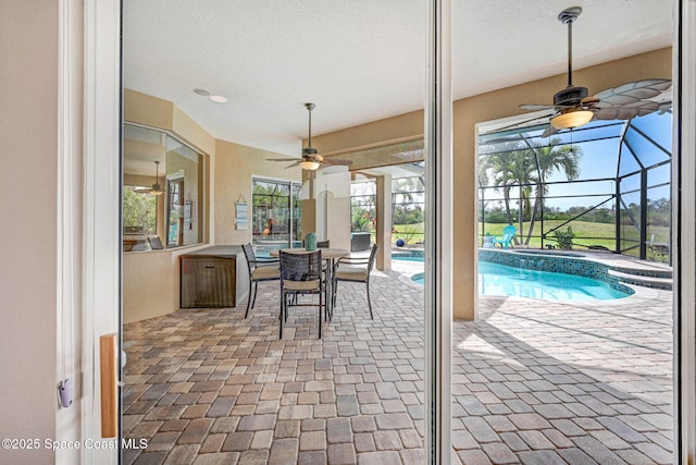 view of patio / terrace with ceiling fan and glass enclosure