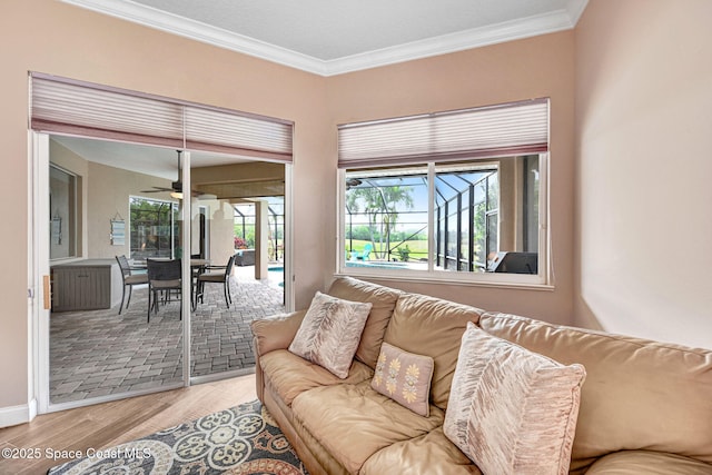 living room featuring crown molding, ceiling fan, and light wood-type flooring