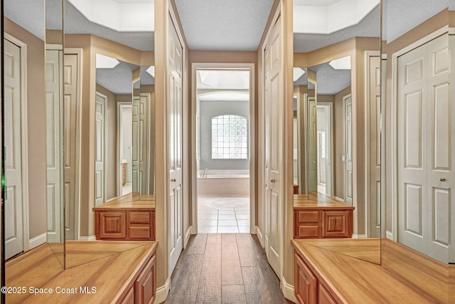 bathroom with a bathtub, hardwood / wood-style flooring, and a textured ceiling