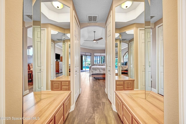 bathroom with hardwood / wood-style floors, a textured ceiling, and ceiling fan