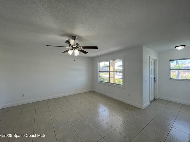 spare room with ceiling fan, a wealth of natural light, and a textured ceiling