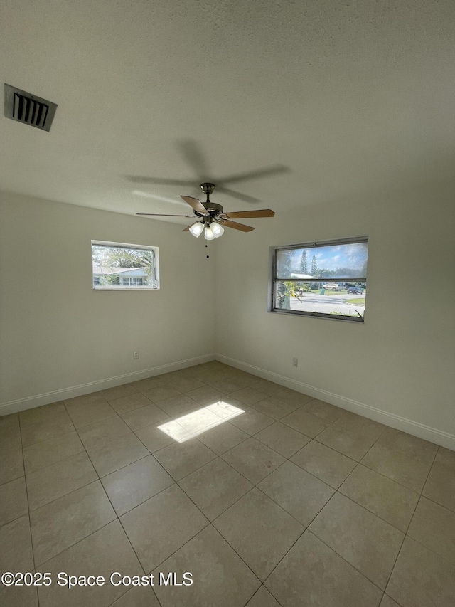 tiled empty room featuring ceiling fan