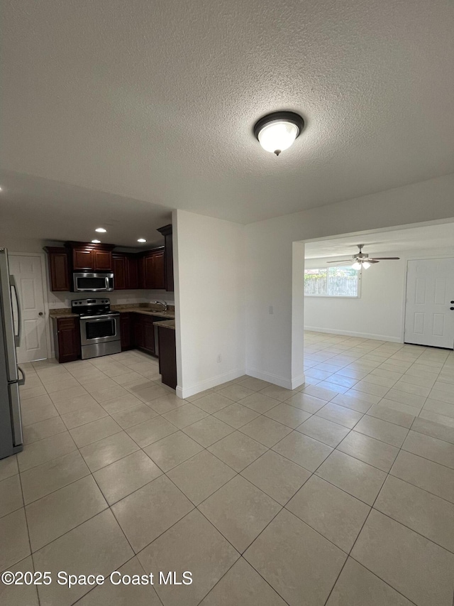 interior space with ceiling fan, sink, and a textured ceiling