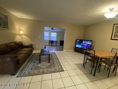 living area featuring baseboards and tile patterned floors