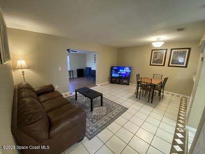 living room featuring light tile patterned flooring and baseboards