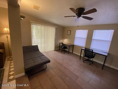 sitting room featuring ceiling fan and baseboards