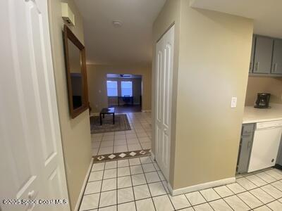 hall featuring light tile patterned flooring and baseboards