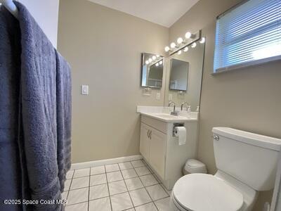 bathroom with baseboards, vanity, toilet, and tile patterned floors