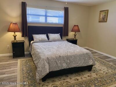 bedroom with baseboards and wood finished floors