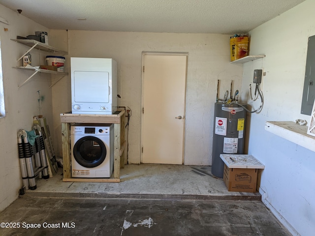 laundry area with laundry area, water heater, and stacked washer / drying machine