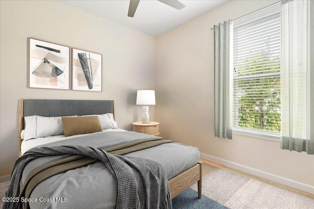 bedroom featuring a ceiling fan, baseboards, and wood finished floors