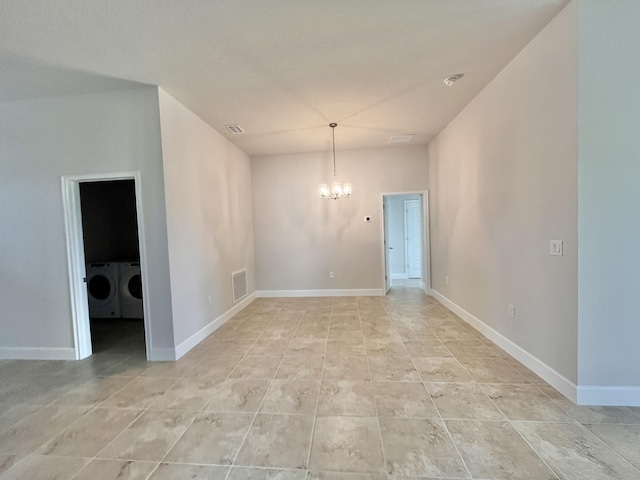 unfurnished room with a notable chandelier and washer and clothes dryer