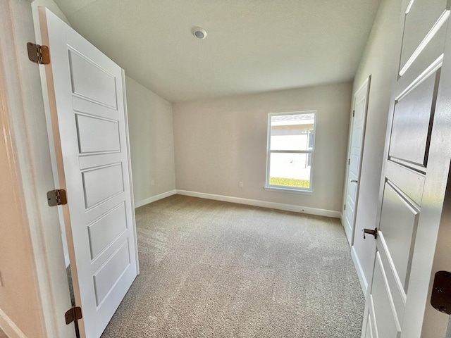 unfurnished room featuring light colored carpet