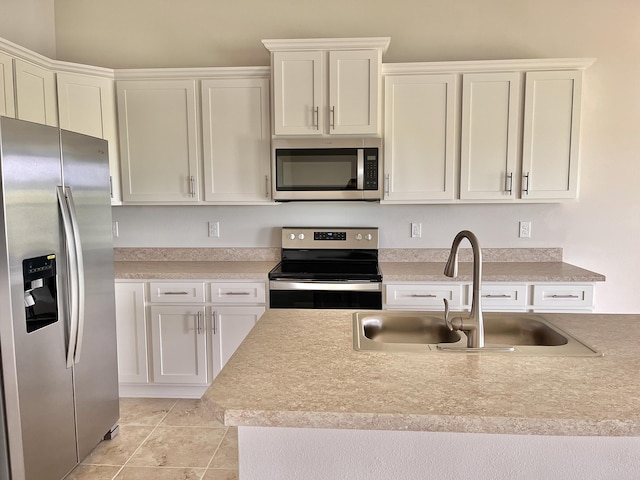 kitchen featuring white cabinetry, sink, light tile patterned flooring, and appliances with stainless steel finishes