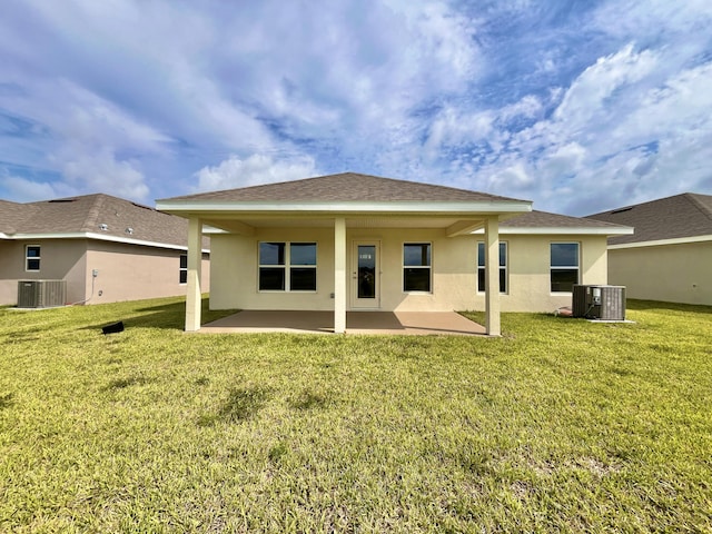 back of house featuring a yard, central AC unit, and a patio area