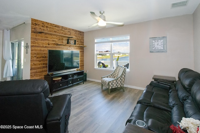 living room with ceiling fan and light hardwood / wood-style flooring