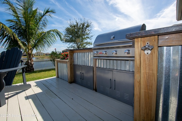 deck with a water view and area for grilling