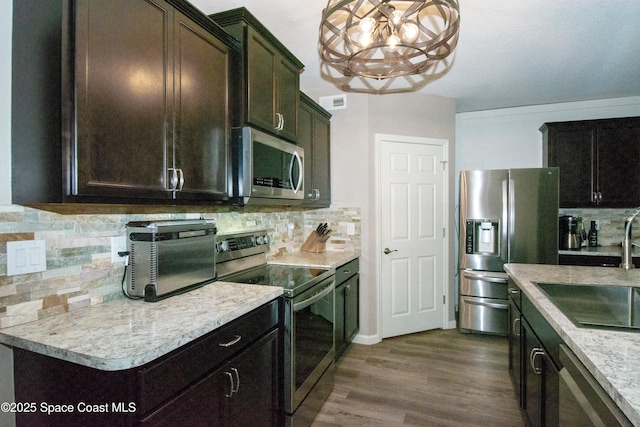 kitchen with decorative light fixtures, tasteful backsplash, sink, dark hardwood / wood-style flooring, and stainless steel appliances