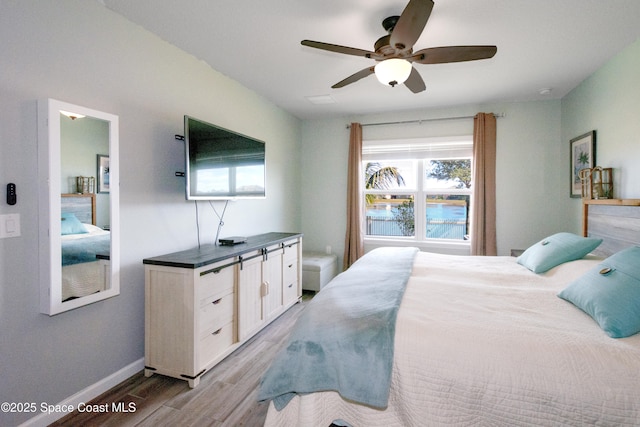 bedroom with light hardwood / wood-style floors and ceiling fan