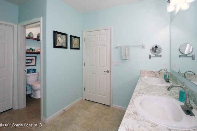 bathroom featuring tile patterned floors, vanity, and toilet