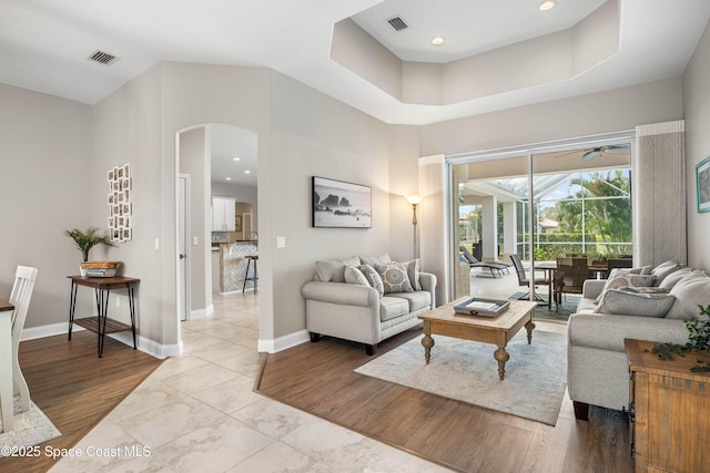 living room with light wood-type flooring and a high ceiling