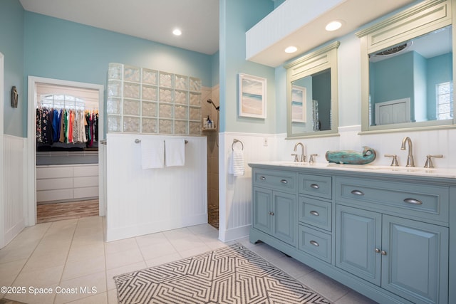 bathroom with tiled shower, vanity, and tile patterned flooring