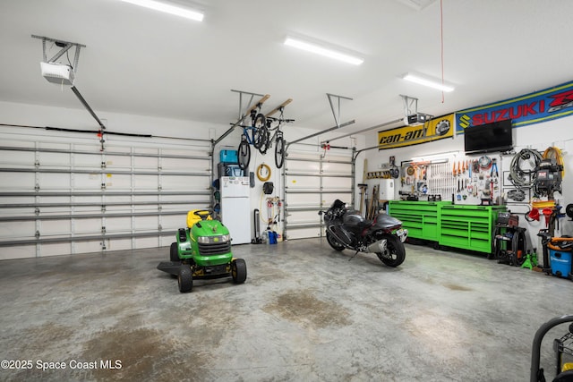 garage featuring a garage door opener, white fridge, and a workshop area