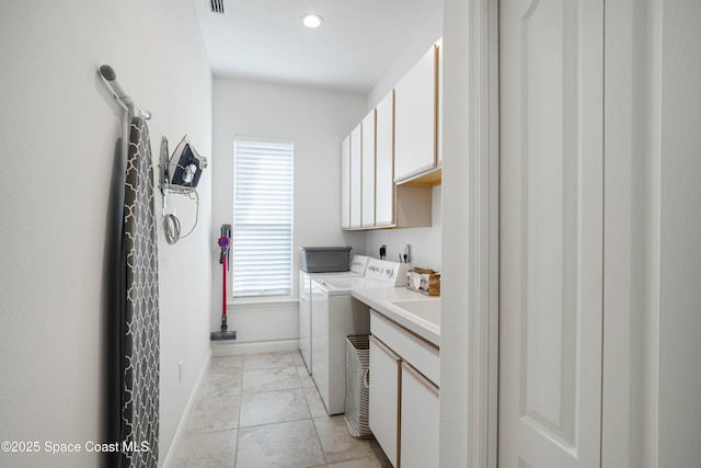 laundry room with sink, washer and clothes dryer, and cabinets