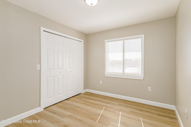 unfurnished bedroom featuring hardwood / wood-style floors and a closet