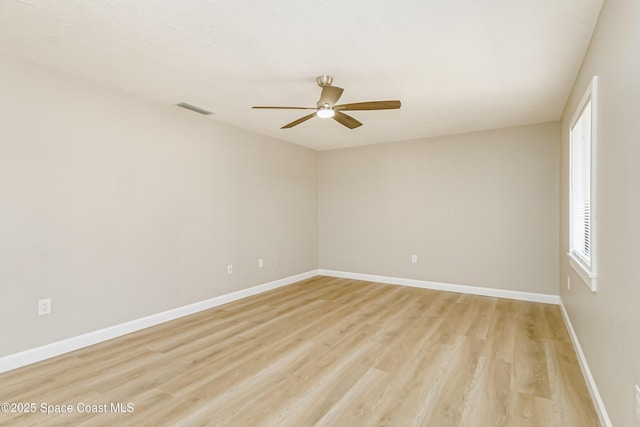 empty room with ceiling fan and light hardwood / wood-style flooring