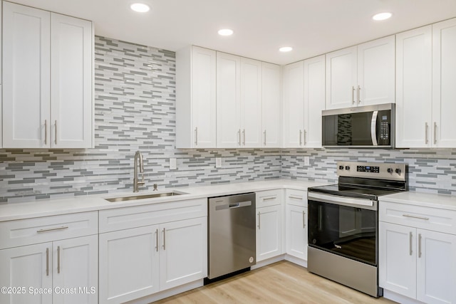 kitchen featuring sink, white cabinets, and appliances with stainless steel finishes