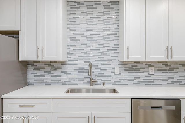 kitchen featuring backsplash, stainless steel appliances, sink, and white cabinets