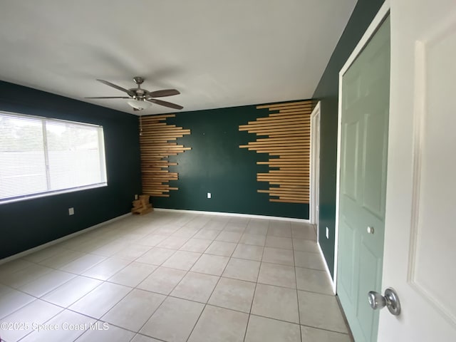 tiled spare room with ceiling fan