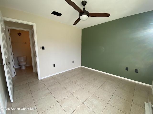 tiled spare room featuring ceiling fan